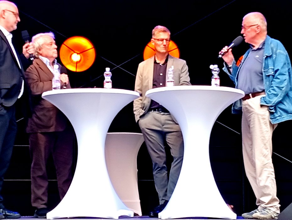 DINO beim NRW-Tag in Münster am 30.8.26 mit v.l.n.r. dem Friedensforscher Dr. Jochen  Reidegeld, Moderator Thomas Nehls, OB Tilmann Fuchs und dem außenpolitischen  Experten Ruprecht Polenz
